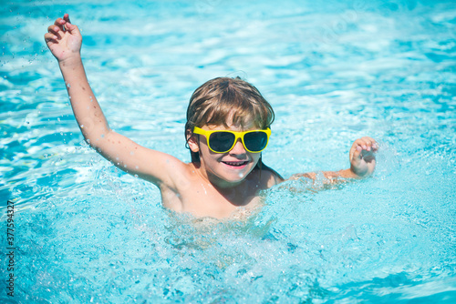 Child in sunglasses on beach. Portrait of cute kid having fun in swimming pool. © Volodymyr