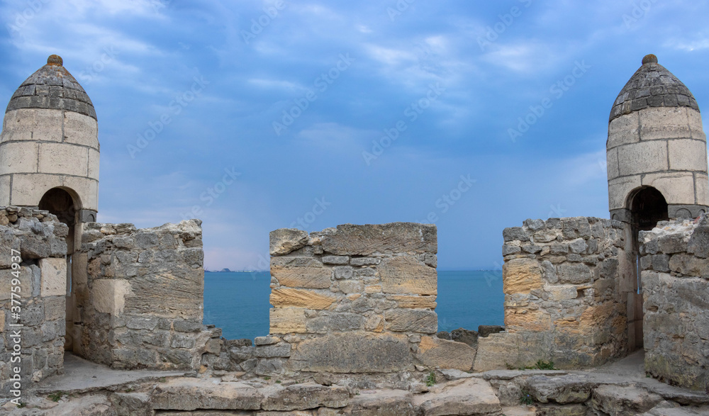 Against the background of a stormy sky, the towers of the Yenikale fortress . Castle, fortress, landscape.Space for text