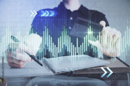 Double exposure of man hands holding a credit card and Forex graph drawing. Stock trading and digital fintech in Internet E-commerce concept.