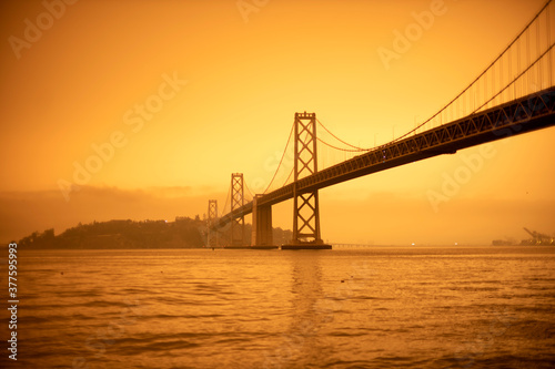 San Francisco Bay bridge and Yerba Buena island under orange ominous sky with fire smoked tinted sky bay bridge Oakland san Francisco Bridge © PIERRE JEAN C