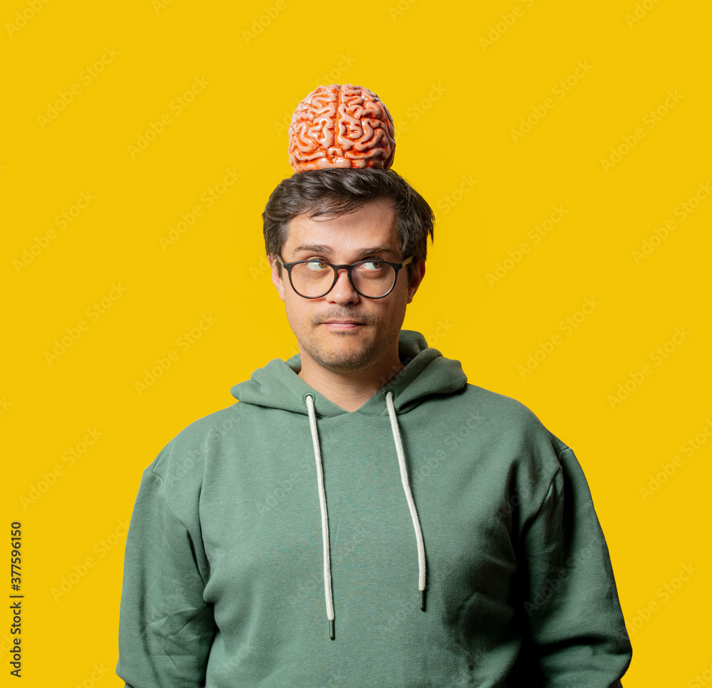 Guy in green hoodie with brain on yellow background Guy in green hoodie with brain on yellow background