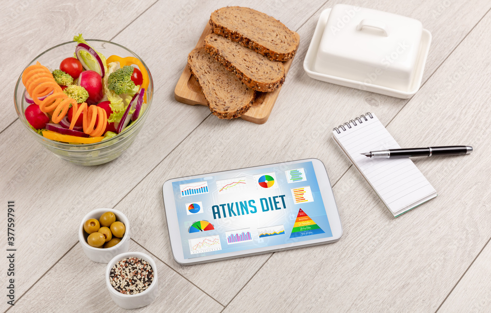 Organic food and tablet pc showing ATKINS DIET inscription, healthy nutrition composition Organic food and tablet pc showing ATKINS DIET inscription, healthy nutrition composition