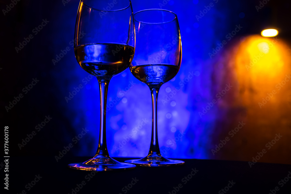 Wine glasses stand on the table on a blue background
