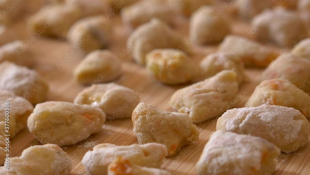 freshly handmade potato dumplings on the chopping board ready to cook - closeup freshly handmade potato dumplings on the chopping board ready to cook - closeup
