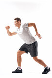 Athletic man on a light background in full growth and jogging charging shorts sneakers t-shirt