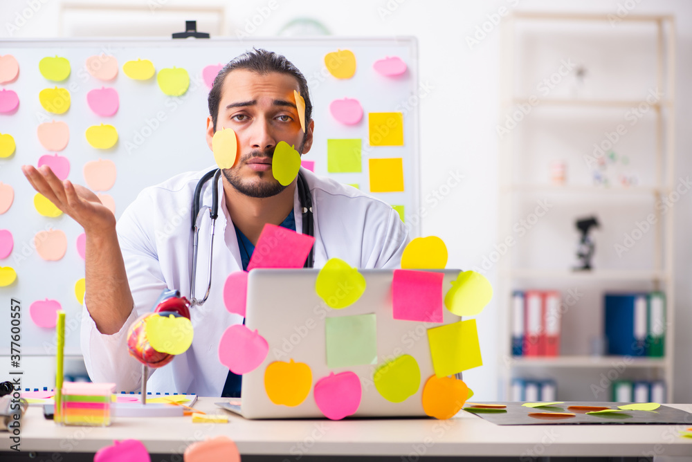 Young male medic in conflicting priorities concept