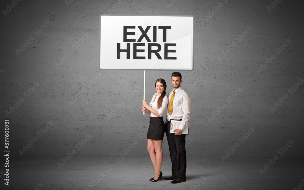 business person holding a traffic sign with EXIT HERE inscription, new idea concept business person holding a traffic sign with EXIT HERE inscription, new idea concept