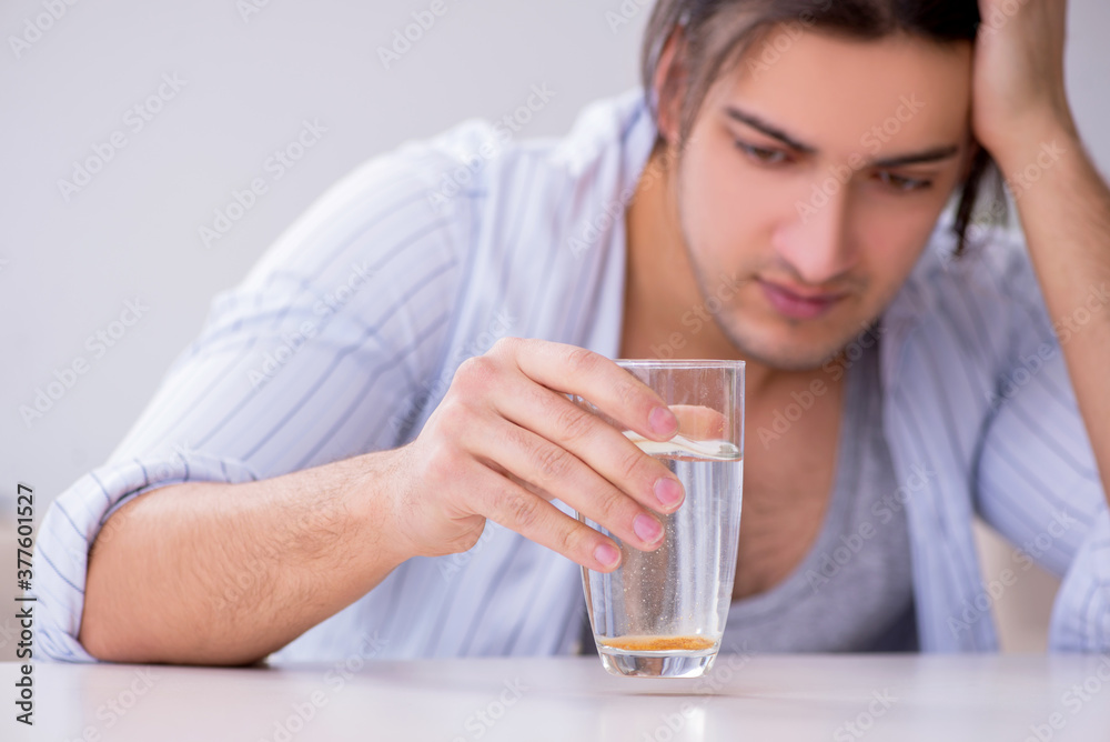Young male alcoholic drinking whiskey at home Young male alcoholic drinking whiskey at home