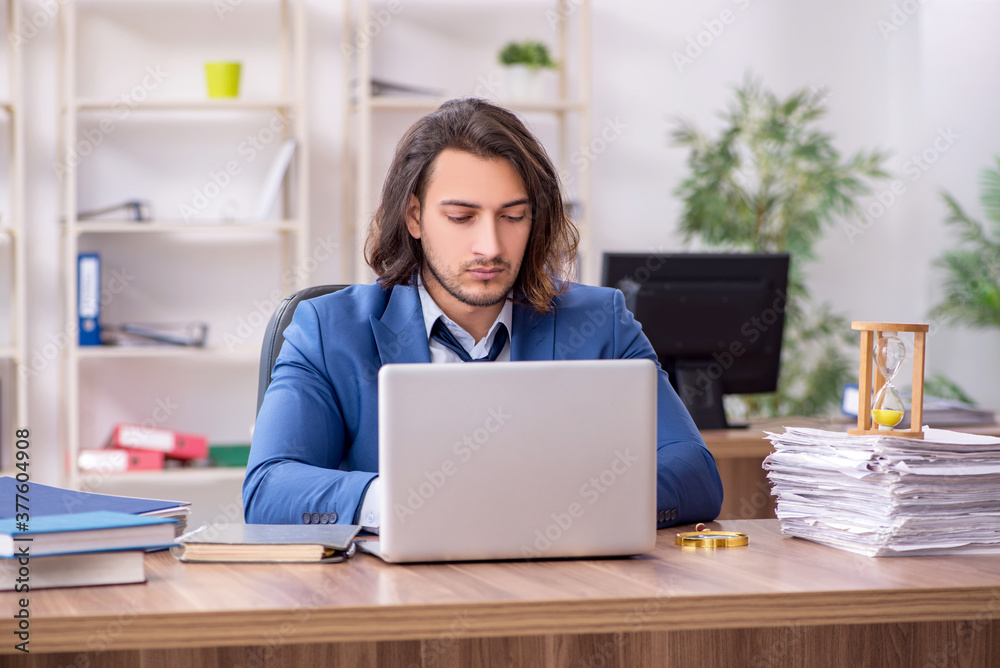 Young male employee unhappy with excessive work Young male employee unhappy with excessive work