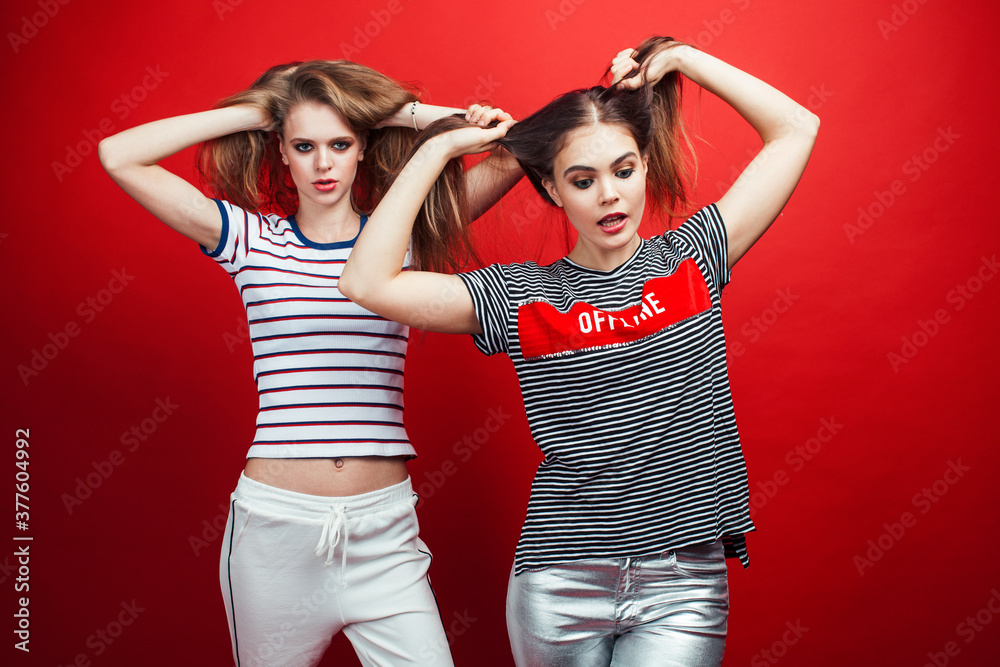two best friends teenage girls together having fun, posing emotional on red background, lifestyle people concept two best friends teenage girls together having fun, posing emotional on red background, lifestyle people concept
