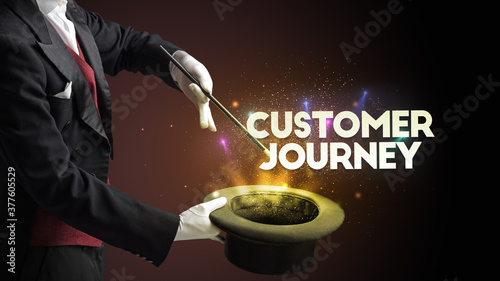 Illusionist is showing magic trick with CUSTOMER JOURNEY inscription, new business model concept