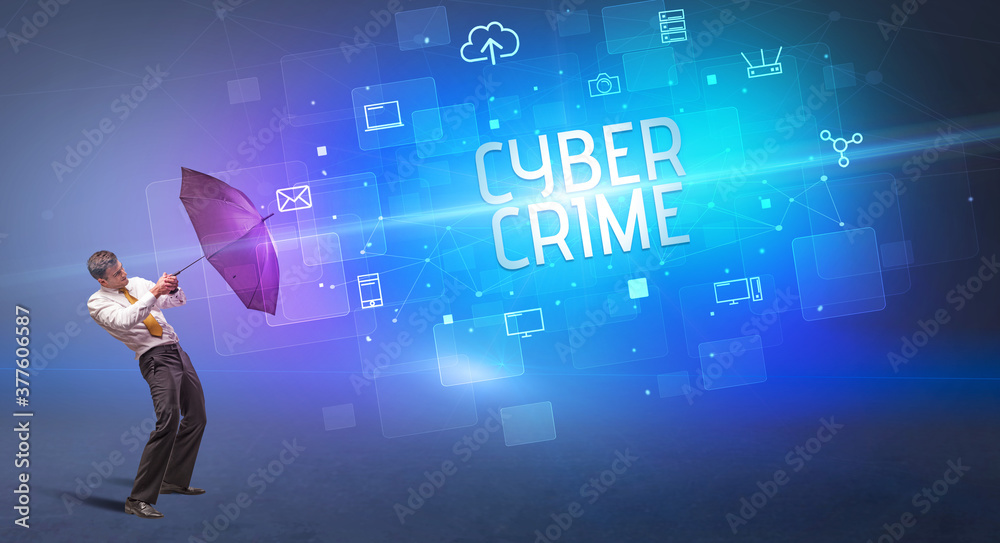 Businessman defending with umbrella from cyber attack and CYBER CRIME inscription, online security concept Businessman defending with umbrella from cyber attack and CYBER CRIME inscription, online security concept