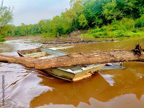 Abandoned boat on the river after a heavy rain