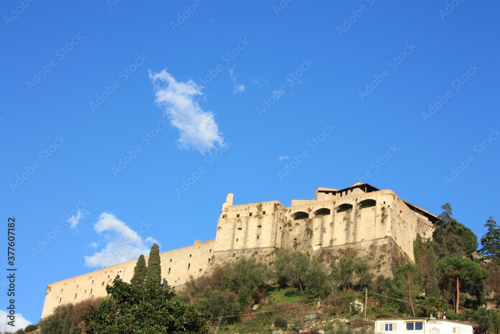 ancient ducal fortress perched on a green hill. building overlooking the plain in the blue sky in Tuscany