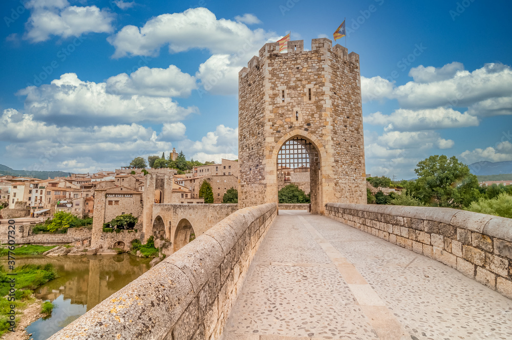 Medieval gated bridge with tower in Besalu Catalonia Spain with cloudy blue sky