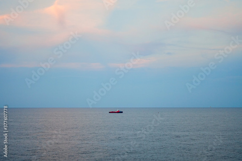lonely sailing boat or crew boat in the sea with beautiful sky and cloud, minimal lonely concept.
