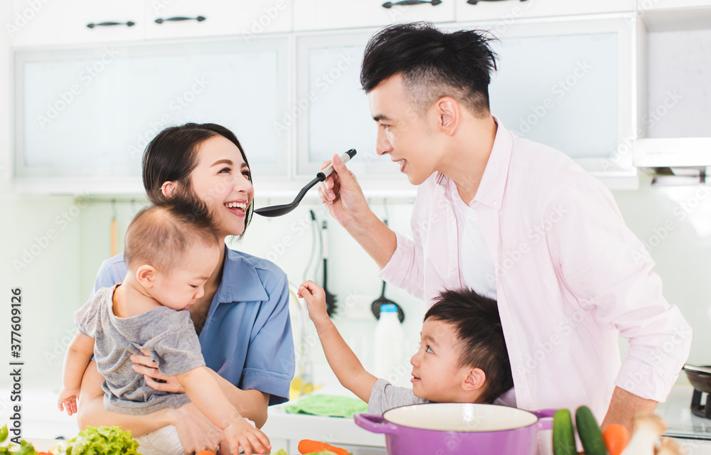 happy family tasting the soup in kitchen happy family tasting the soup in kitchen