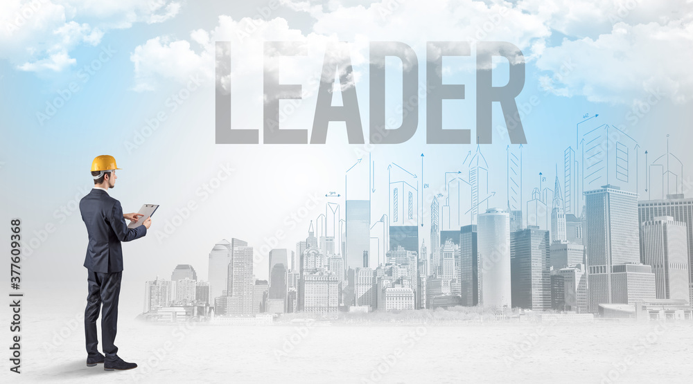 Young businessman with hard hat and LEADER inscription, new business opportunity concept Young businessman with hard hat and LEADER inscription, new business opportunity concept