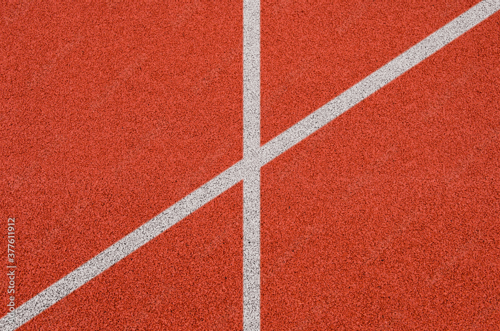 Top view of the running track rubber lanes cover texture with white line marking for background. Top view of the running track rubber lanes cover texture with white line marking for background.