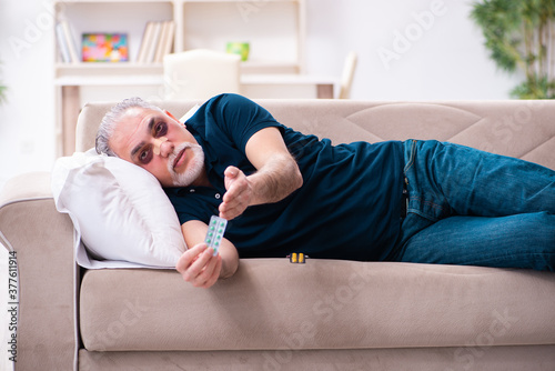 Old man with injured eyes resting at home