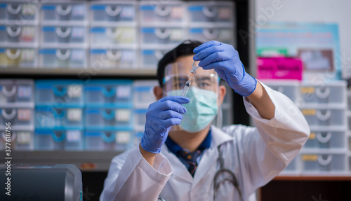 Doctor, nurse, scientist, researcher hand in blue gloves holding flu, measles, coronavirus, covid-19 vaccine disease preparing for human clinical trials vaccination shot, medicine and drug concept.