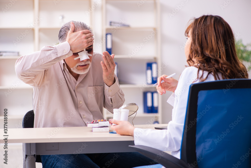 Naklejka premium Old man visiting young female doctor for plastic surgery