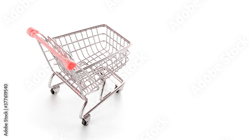 Sale background. Empty trolley cart for supermarket isolated on white background. Food shopping basket for retail market. Discount promotion and Black Friday concept. Copy space for text.