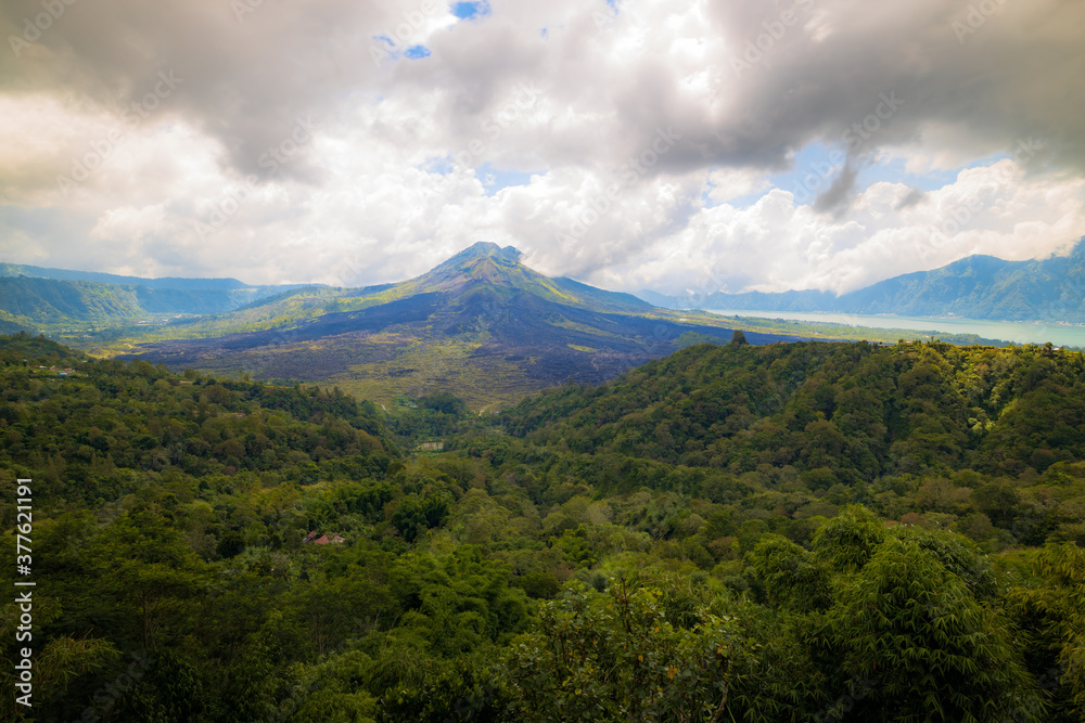 Beautiful mountain landscape. Hills and Batur volcano. Scenic panoramic view. Sky with white clouds. Kintamani, Bali, Indonesia Beautiful mountain landscape. Hills and Batur volcano. Scenic panoramic view. Sky with white clouds. Kintamani, Bali, Indonesia