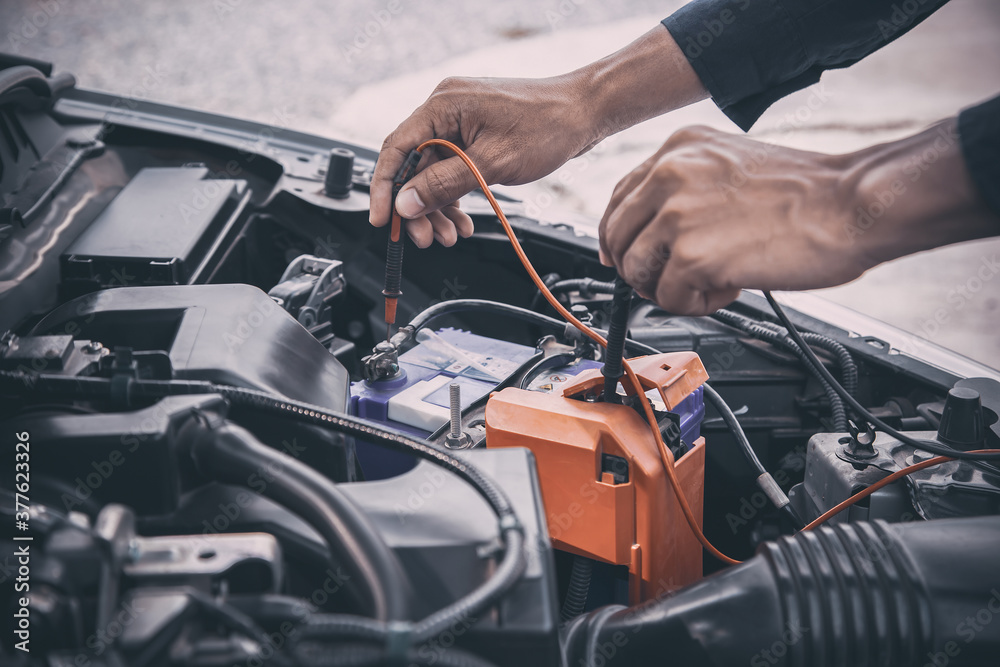 Auto mechanic are using measuring equipment tool for checking car battery. Concepts of Old car fix repair and service insurance. Auto mechanic are using measuring equipment tool for checking car battery. Concepts of Old car fix repair and service insurance.
