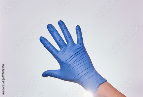 Mano de hombre con guantes de nitrilo en fondo blanco