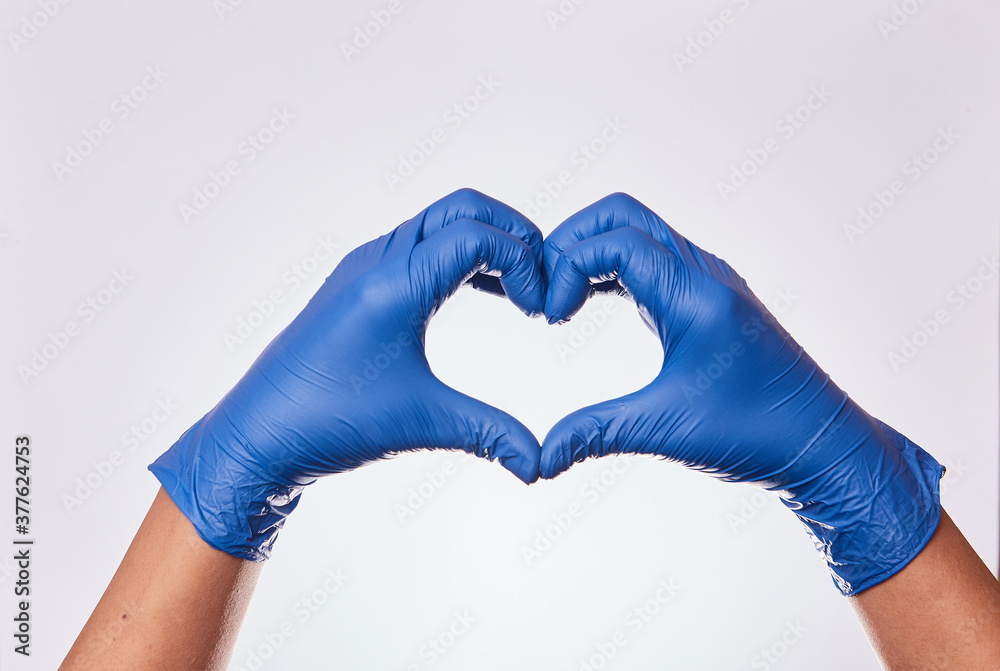 Mano de hombre formando un corazón con guantes de nitrilo en fondo blanco.  Simbolos de afecto y amor con manos. Stock Photo