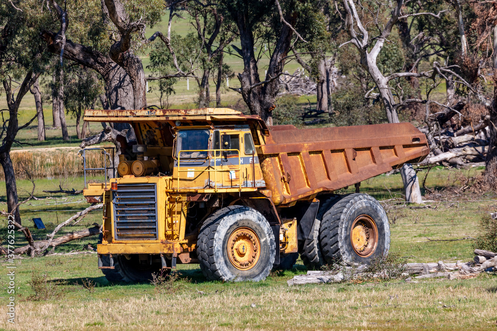 An old rusty earthmoving truck in a green field in regional Australia An old rusty earthmoving truck in a green field in regional Australia