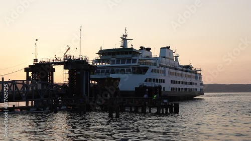 Mukilteo ferry leaves dock to cross Puget Sound in Washington state at sunset photo