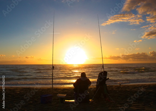 fisherman relaxes by the sea at sunset time waiting for the fish of the ocean to take the bait
