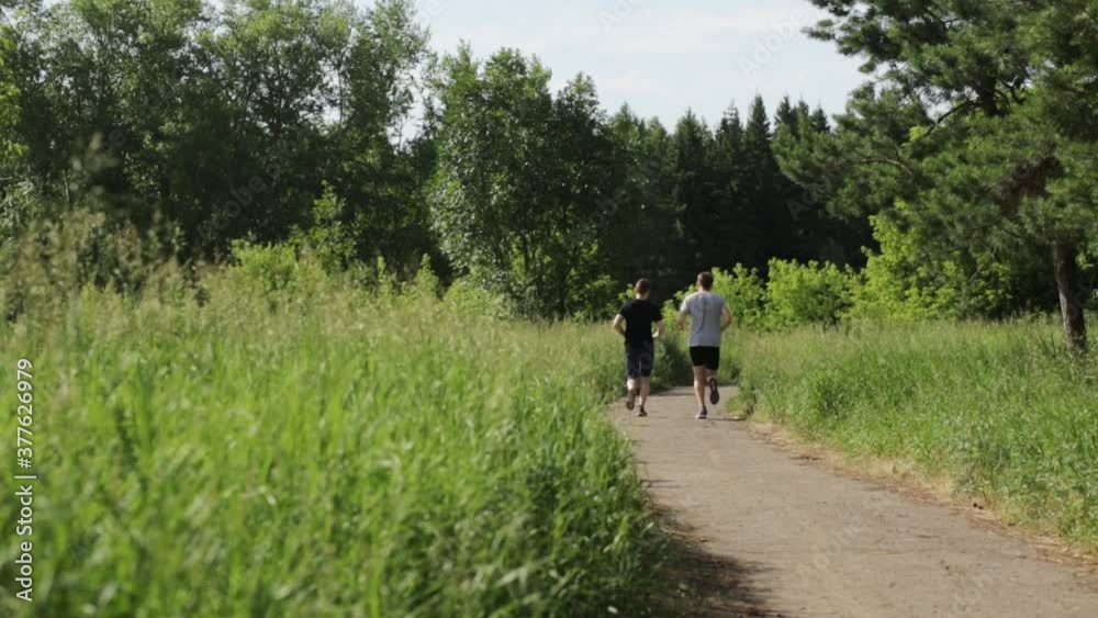 two Men in sportswear are running in the park. Outdoor sports. two Men in sportswear are running in the park. Outdoor sports.
