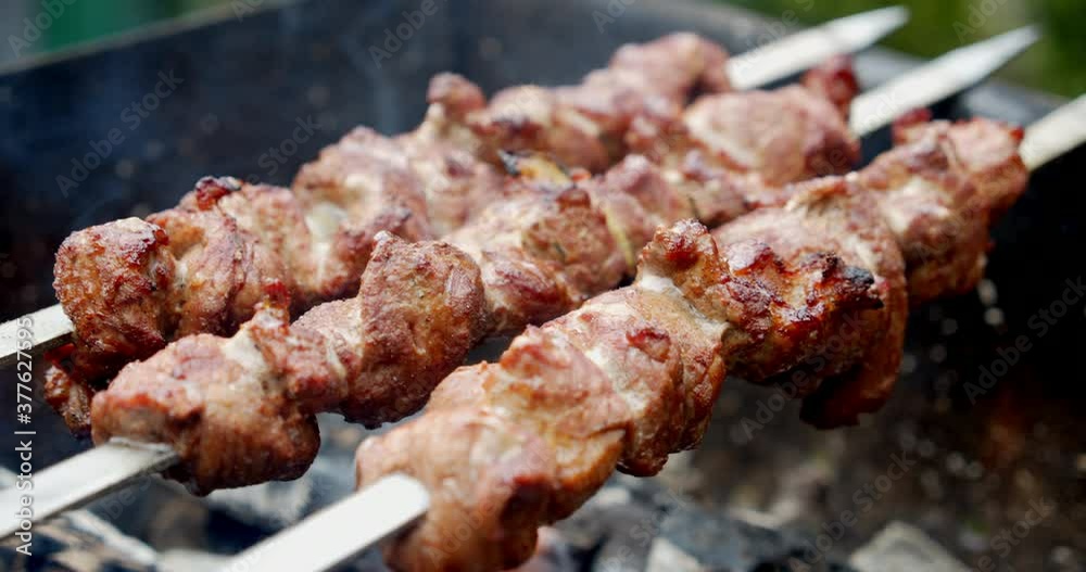 A kebab of fresh meat is fried over flame of fire. A kebab of fresh meat is fried over flame of fire.