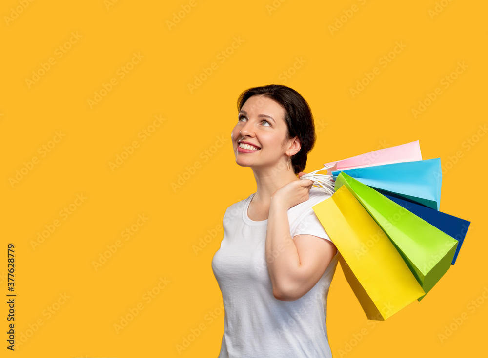 Shopaholic lifestyle. Sale and discount. Happy woman holding pink and blue bags. Isolated on orange copy space. Pleasant purchase. Black friday. Cyber monday. Holiday gifts Shopaholic lifestyle. Sale and discount. Happy woman holding pink and blue bags. Isolated on orange copy space. Pleasant purchase. Black friday. Cyber monday. Holiday gifts