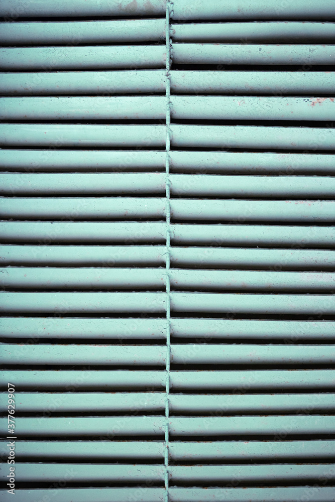 Obraz premium View of the turquoise outdoor ventilation grill. Old rusty ventilation grill