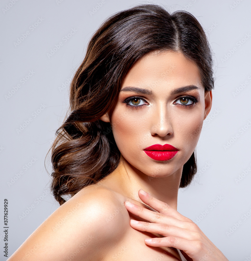 Beautiful young fashion woman with red lipstick. Brunette woman with a clean skin of face. Portrait of model with bright red lips. Glamour fashion model with bright gloss make-up posing at studio. Beautiful young fashion woman with red lipstick. Brunette woman with a clean skin of face. Portrait of model with bright red lips. Glamour fashion model with bright gloss make-up posing at studio.
