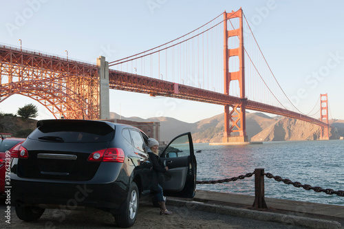 View of a girl coming out of the car near golden gate in San francisco photo