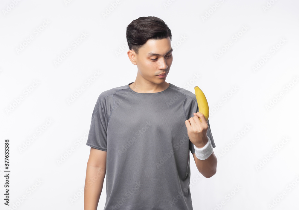 Young handsome asian sport man holding banana with smiling isolated on white background. Healthy lifestyle concept. Young handsome asian sport man holding banana with smiling isolated on white background. Healthy lifestyle concept.
