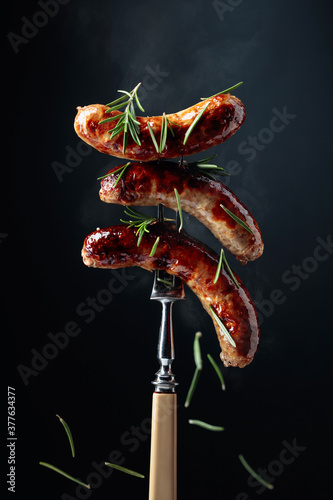 Steaming grilled sausages with rosemary.