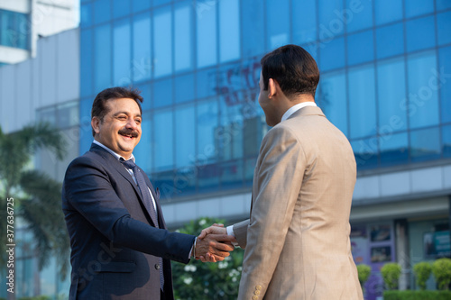 Photography Businessman and businesswoman shaking hands on city street