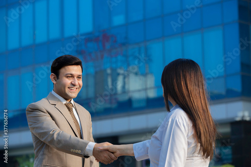 Photography Businessman and businesswoman shaking hands on city street