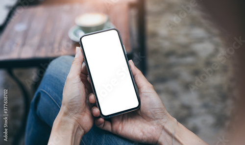 cell phone mockup blank white screen.woman hand holding texting using mobile on desk at coffee shop.background empty space for advertise.work people contact marketing business,technology