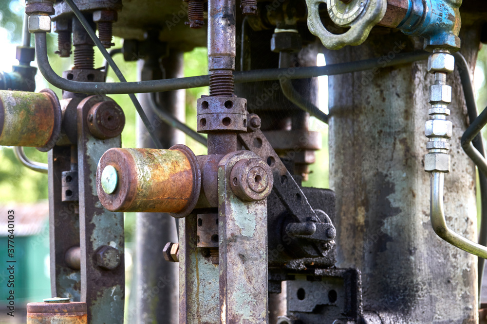 Valves, connection, fittings and steering wheels on an old mechanical pump Valves, connection, fittings and steering wheels on an old mechanical pump