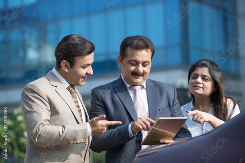 Canvas Print Business colleagues using digital tablet outdoors