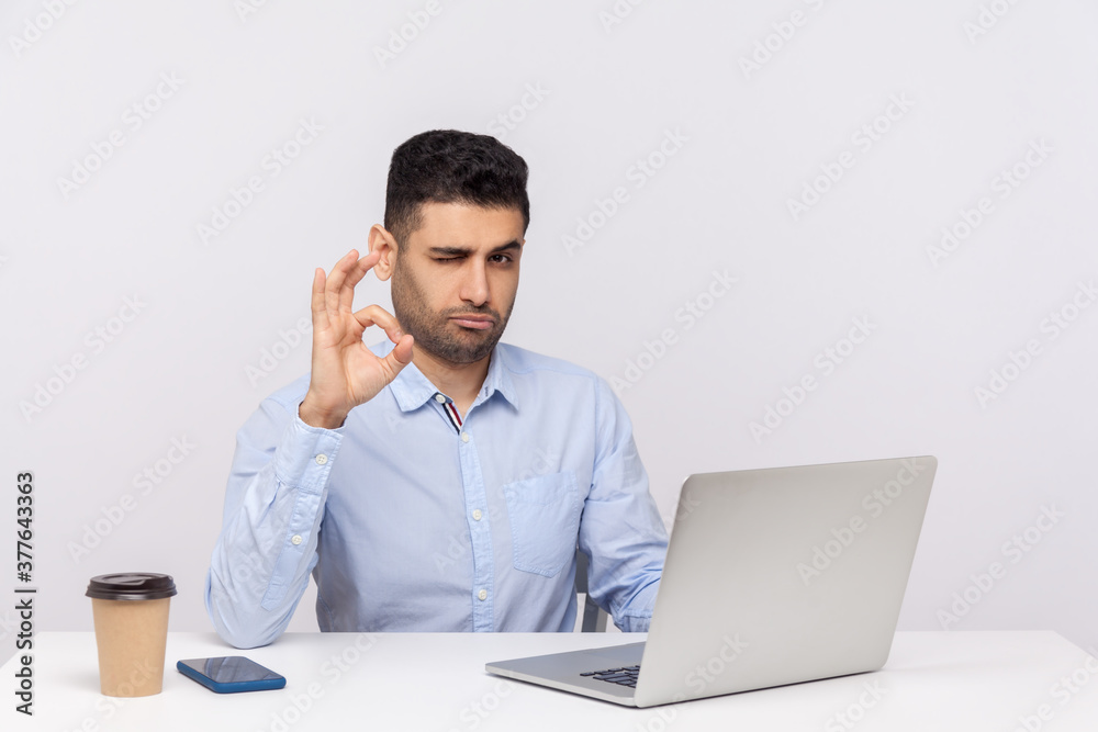 Okay! Happy optimistic businessman sitting office workplace, showing ok finger gesture, approving suggestion, completely agree with business plan. indoor studio shot isolated on white background Okay! Happy optimistic businessman sitting office workplace, showing ok finger gesture, approving suggestion, completely agree with business plan. indoor studio shot isolated on white background