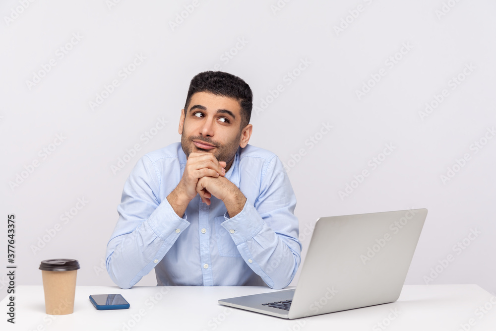 Optimistic happy businessman sitting office workplace with laptop on desk, leaning on hands while dreaming, making wish, musing thinking inspired. indoor studio shot isolated on white background Optimistic happy businessman sitting office workplace with laptop on desk, leaning on hands while dreaming, making wish, musing thinking inspired. indoor studio shot isolated on white background