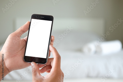 Close up of a man hand holding the black smart phone with white screen and blurred background.